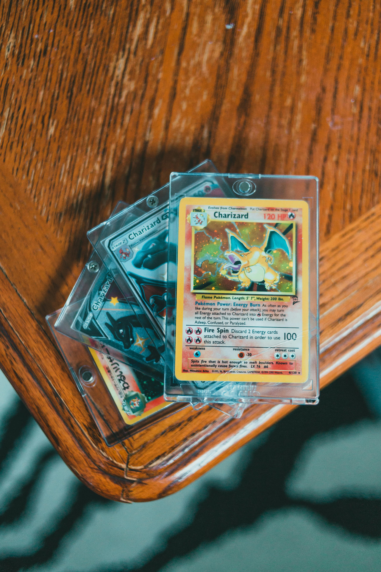 Cartes Charizard protégées posées sur une table en bois